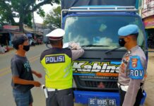Personel Satlantas Polres Tulang Bawang sedang memasang stiker pada kendaraan truck saat menggelar Operasi Zebra Krakatau-2020