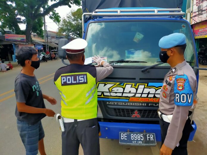 Personel Satlantas Polres Tulang Bawang sedang memasang stiker pada kendaraan truck saat menggelar Operasi Zebra Krakatau-2020