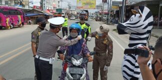 Pengendara yang mendapatkan helm gratis dari Satlantas Polres Tulang Bawang saat mengelar Gebyar Simpatik pada Operasi Zebra Krakatau-2020 di Pasar Unit 2