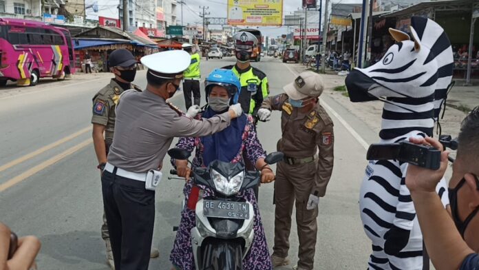 Pengendara yang mendapatkan helm gratis dari Satlantas Polres Tulang Bawang saat mengelar Gebyar Simpatik pada Operasi Zebra Krakatau-2020 di Pasar Unit 2