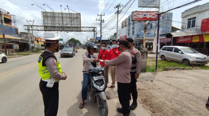 Ka Pos Pam Pasar Unit 2 dengan petugas gabungan saat memberhentikan warga yang tidak patuhi prokes