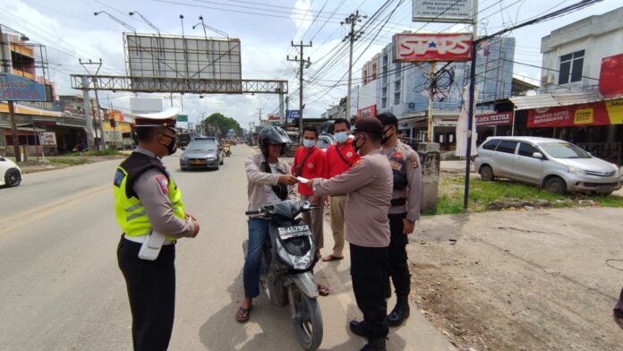 Ka Pos Pam Pasar Unit 2 dengan petugas gabungan saat memberhentikan warga yang tidak patuhi prokes